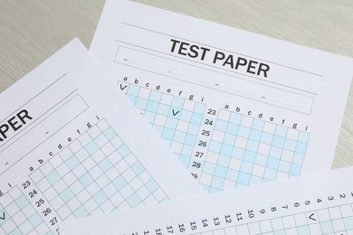 Photo of Answer sheets on wooden table, flat lay. Student passing exam