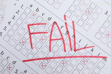 Photo of Word Fail written with red marker on answer sheet, top view. Student passing exam