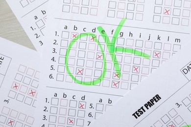 Photo of Answer sheets with word Ok on table, top view. Student passing exam