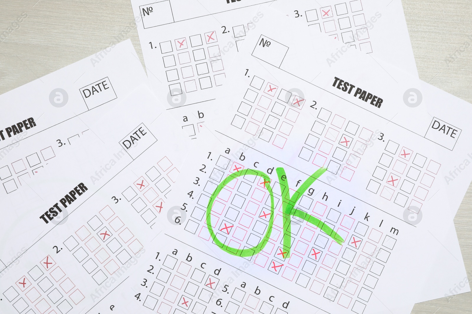 Answer sheets with word Ok on wooden table, top view. Student passing exam Photo of Answer sheets with word Ok on wooden table, top view. Student passing exam