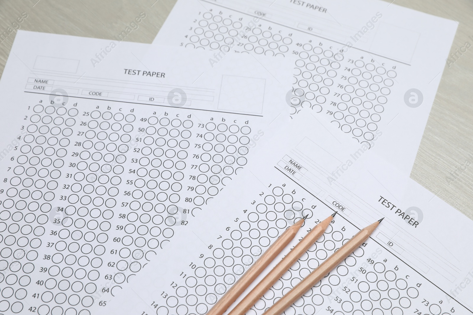 Answer sheets and pencils on wooden table, closeup. Student passing exam Photo of Answer sheets and pencils on wooden table, closeup. Student passing exam