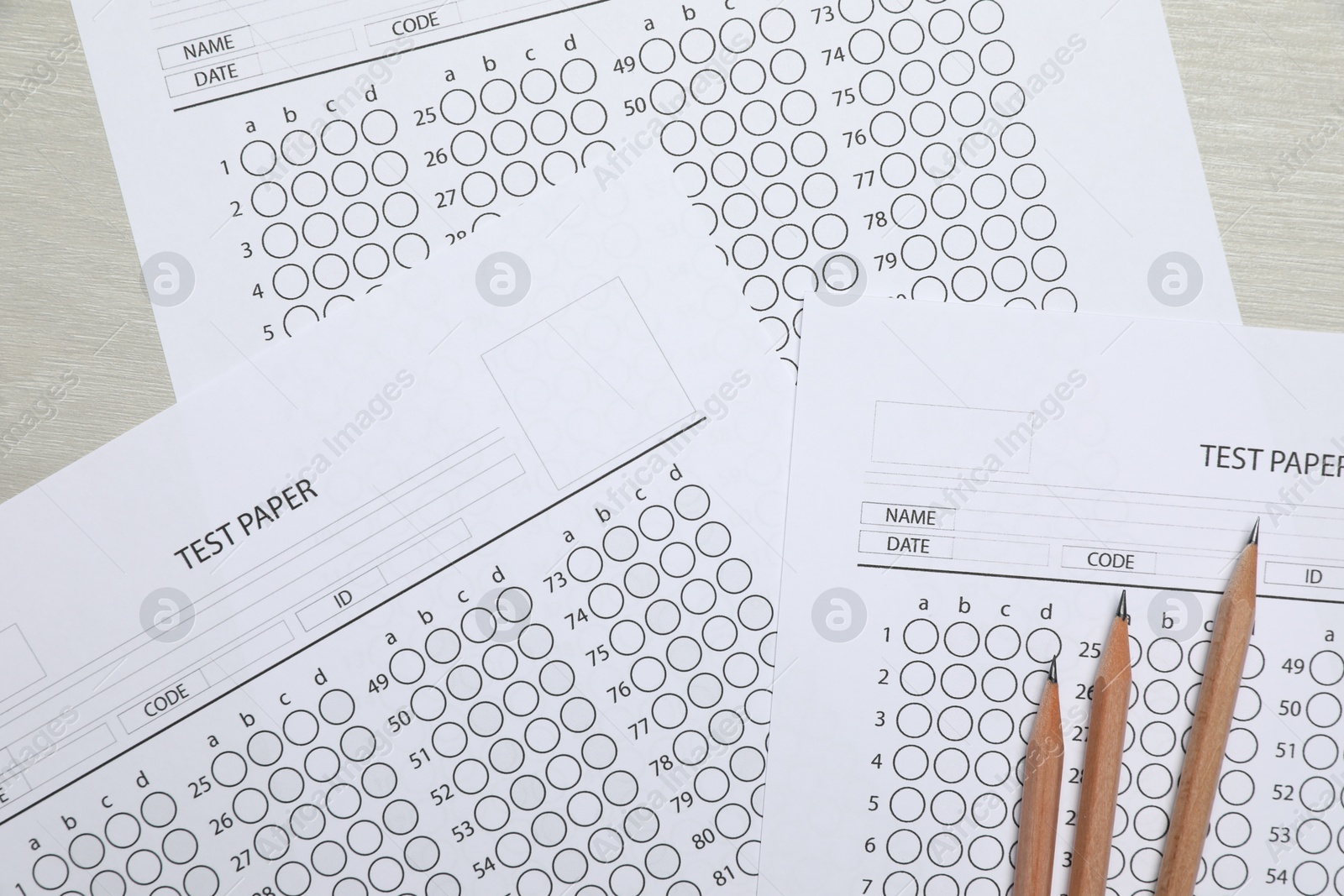 Answer sheets and pencils on wooden table, flat lay. Student passing exam Photo of Answer sheets and pencils on wooden table, flat lay. Student passing exam