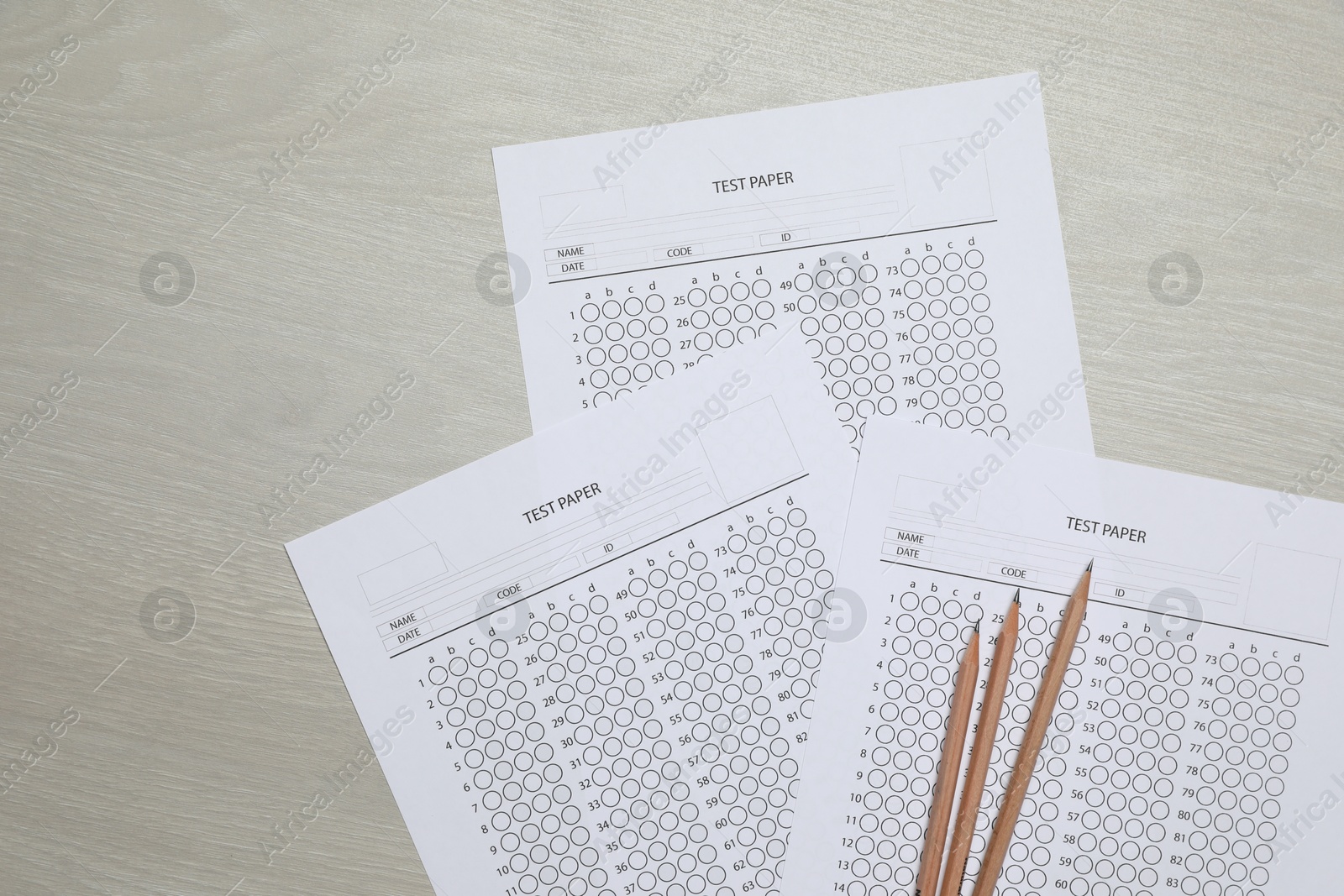 Answer sheets and pencils on wooden table, flat lay. Student passing exam Photo of Answer sheets and pencils on wooden table, flat lay. Student passing exam
