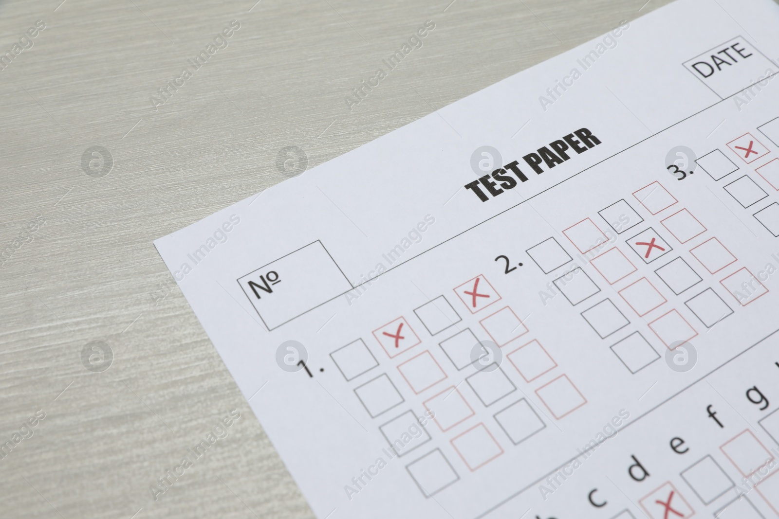Answer sheet on wooden table, closeup. Student passing exam Photo of Answer sheet on wooden table, closeup. Student passing exam