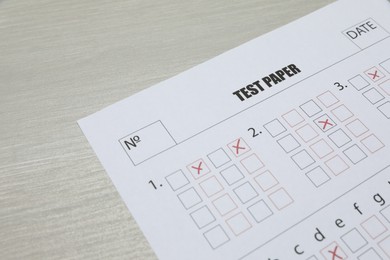 Photo of Answer sheet on wooden table, closeup. Student passing exam