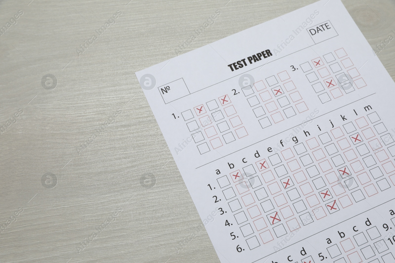 Answer sheet on wooden table, above view. Student passing exam Photo of Answer sheet on wooden table, above view. Student passing exam