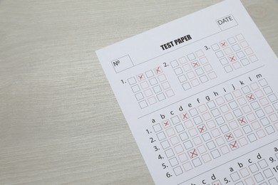 Photo of Answer sheet on wooden table, above view. Student passing exam