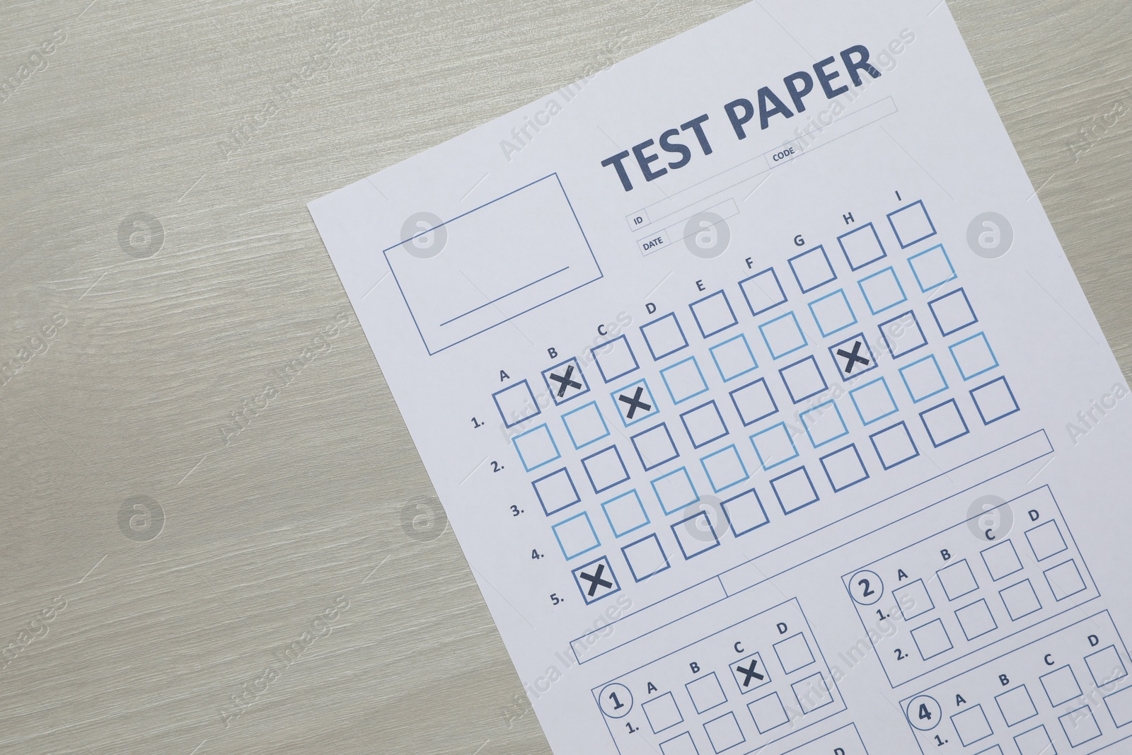Answer sheet on wooden table, top view. Student passing exam Photo of Answer sheet on wooden table, top view. Student passing exam
