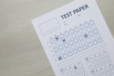 Photo of Answer sheet on wooden table, top view. Student passing exam