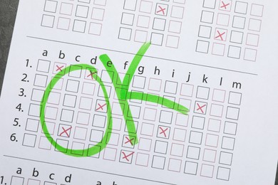Photo of Word OK written with green marker on answer sheet, top view. Student passing exam