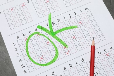 Photo of Answer sheet with word Ok and pencil on table, top view. Student passing exam