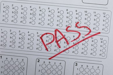 Photo of Word Pass written with red marker on answer sheet, top view. Student passing exam