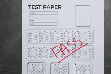 Photo of Answer sheet with word Pass on gray textured table, top view. Student passing exam