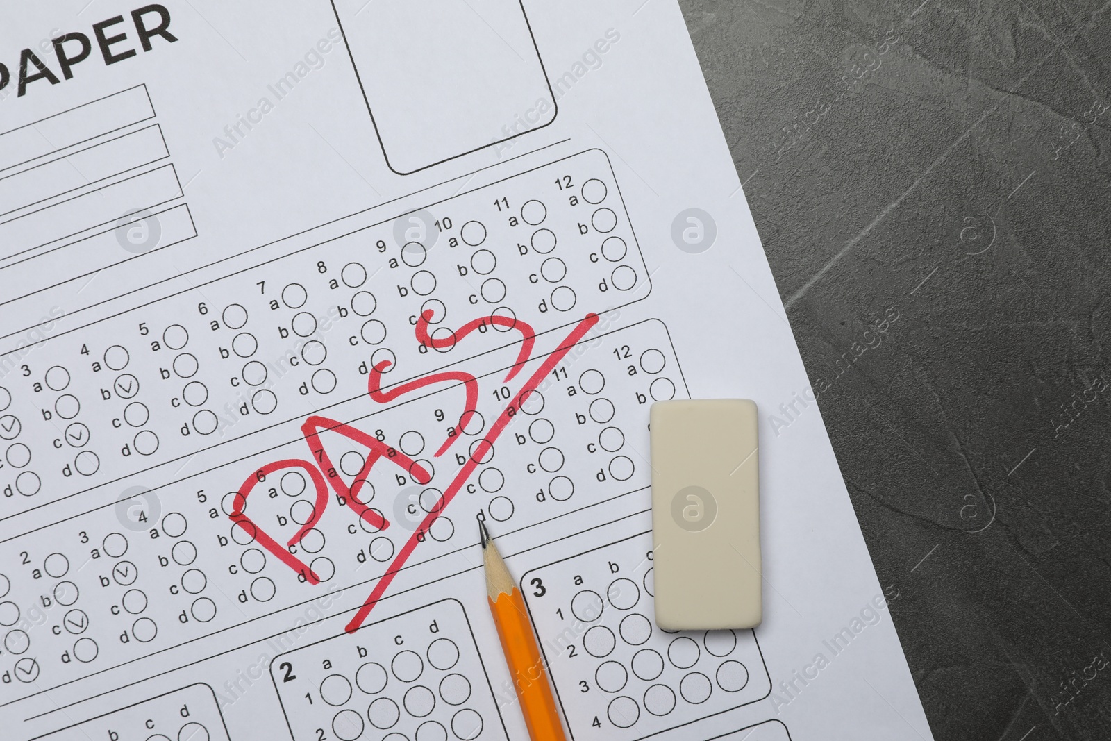 Answer sheet with word Pass, eraser and pencil on gray textured table, flat lay. Student passing exam Photo of Answer sheet with word Pass, eraser and pencil on gray textured table, flat lay. Student passing exam