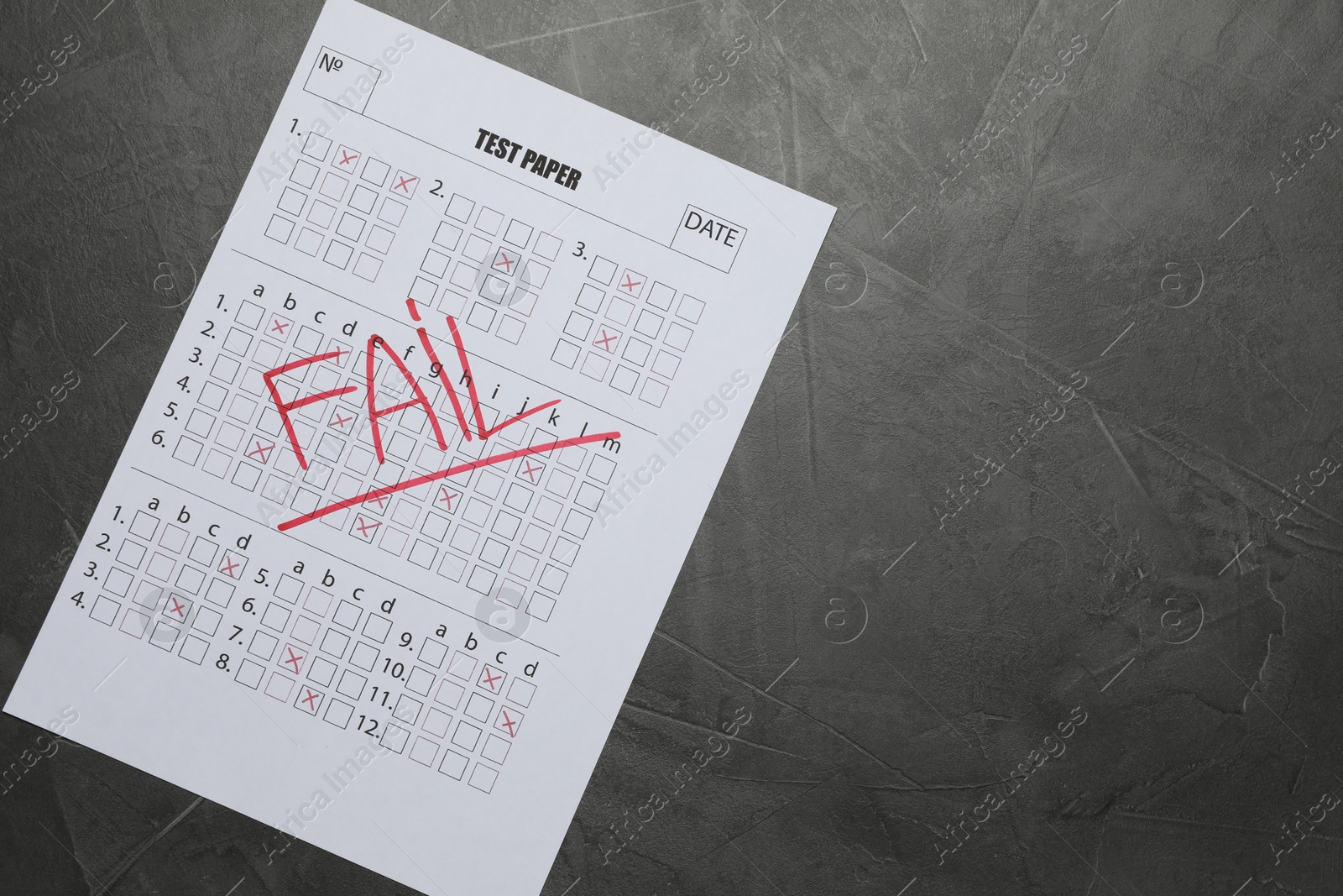 Student passing exam. Answer sheet with word Fail on gray textured table, top view. Space for text Photo of Student passing exam. Answer sheet with word Fail on gray textured table, top view. Space for text