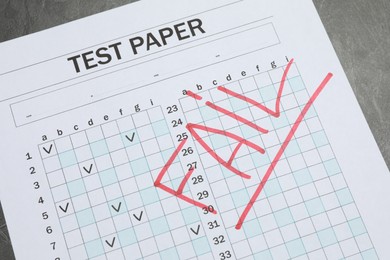Photo of Answer sheet with word Fail on gray table, above view. Student passing exam