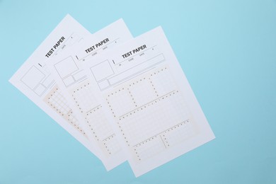 Photo of Answer sheets on light blue background, flat lay. Student passing exam