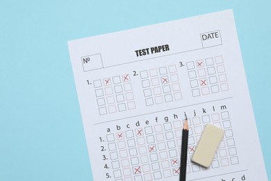 Photo of Answer sheet, pencil and eraser on light blue background, flat lay. Student passing exam