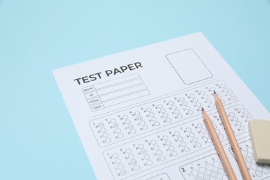 Photo of Answer sheet, pencils and eraser on light blue background, closeup. Student passing exam