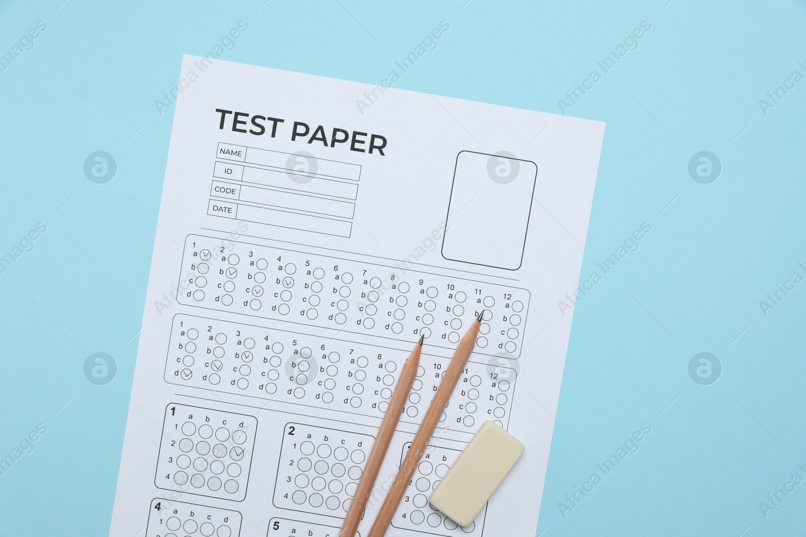 Answer sheet, pencils and eraser on light blue background, flat lay. Student passing exam Photo of Answer sheet, pencils and eraser on light blue background, flat lay. Student passing exam