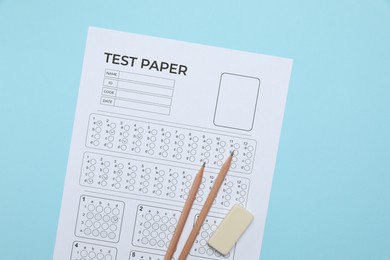 Photo of Answer sheet, pencils and eraser on light blue background, flat lay. Student passing exam