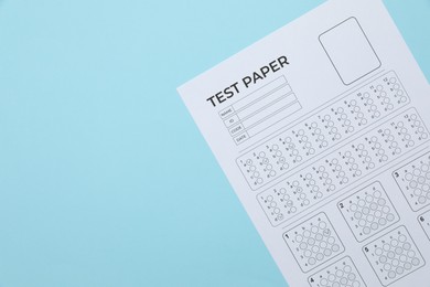 Photo of Student passing exam. Answer sheet on light blue background, top view. Space for text