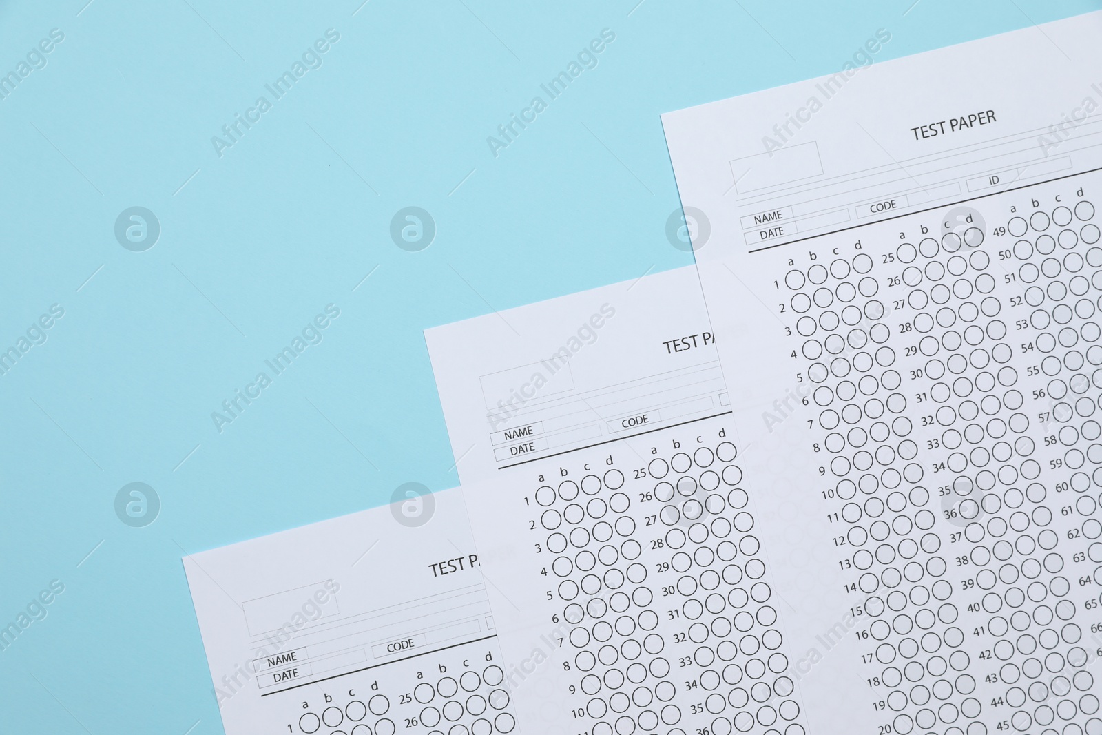 Answer sheets on light blue background, flat lay. Student passing exam Photo of Answer sheets on light blue background, flat lay. Student passing exam