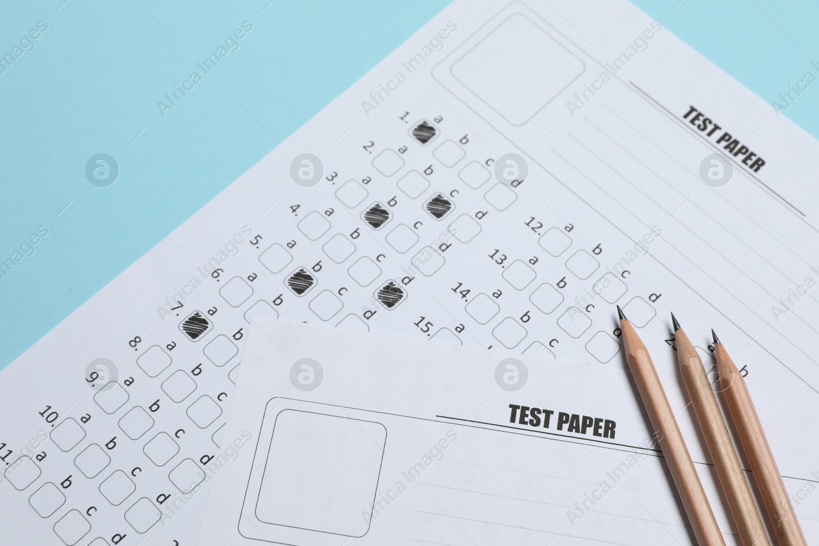Answer sheets and pencils on light blue background, flat lay. Student passing exam Photo of Answer sheets and pencils on light blue background, flat lay. Student passing exam