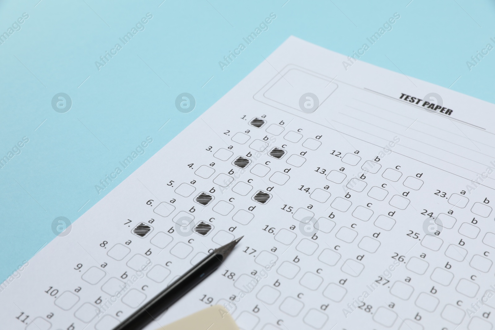Answer sheet and pencil on light blue background, closeup. Student passing exam Photo of Answer sheet and pencil on light blue background, closeup. Student passing exam