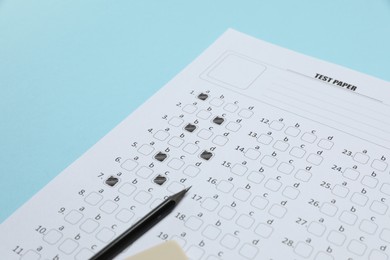 Photo of Answer sheet and pencil on light blue background, closeup. Student passing exam
