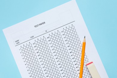 Photo of Answer sheet, pencil and eraser on light blue background, flat lay. Student passing exam