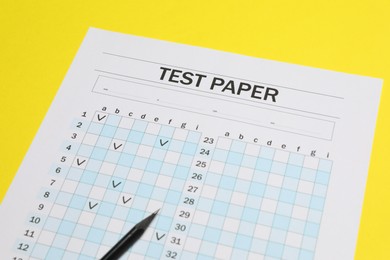 Photo of Answer sheet and pencil on yellow background, closeup. Student passing exam