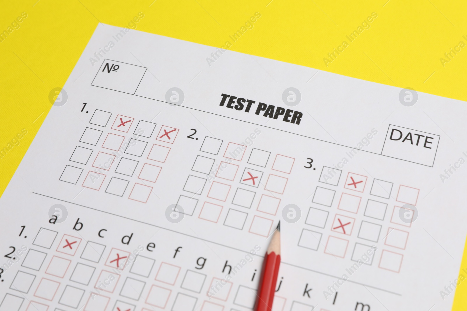 Photo of Answer sheet and pencil on yellow background, closeup. Student passing exam