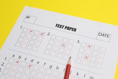 Photo of Answer sheet and pencil on yellow background, closeup. Student passing exam
