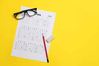Photo of Student passing exam. Answer sheet, glasses, pencil and eraser on yellow background, flat lay. Space for text