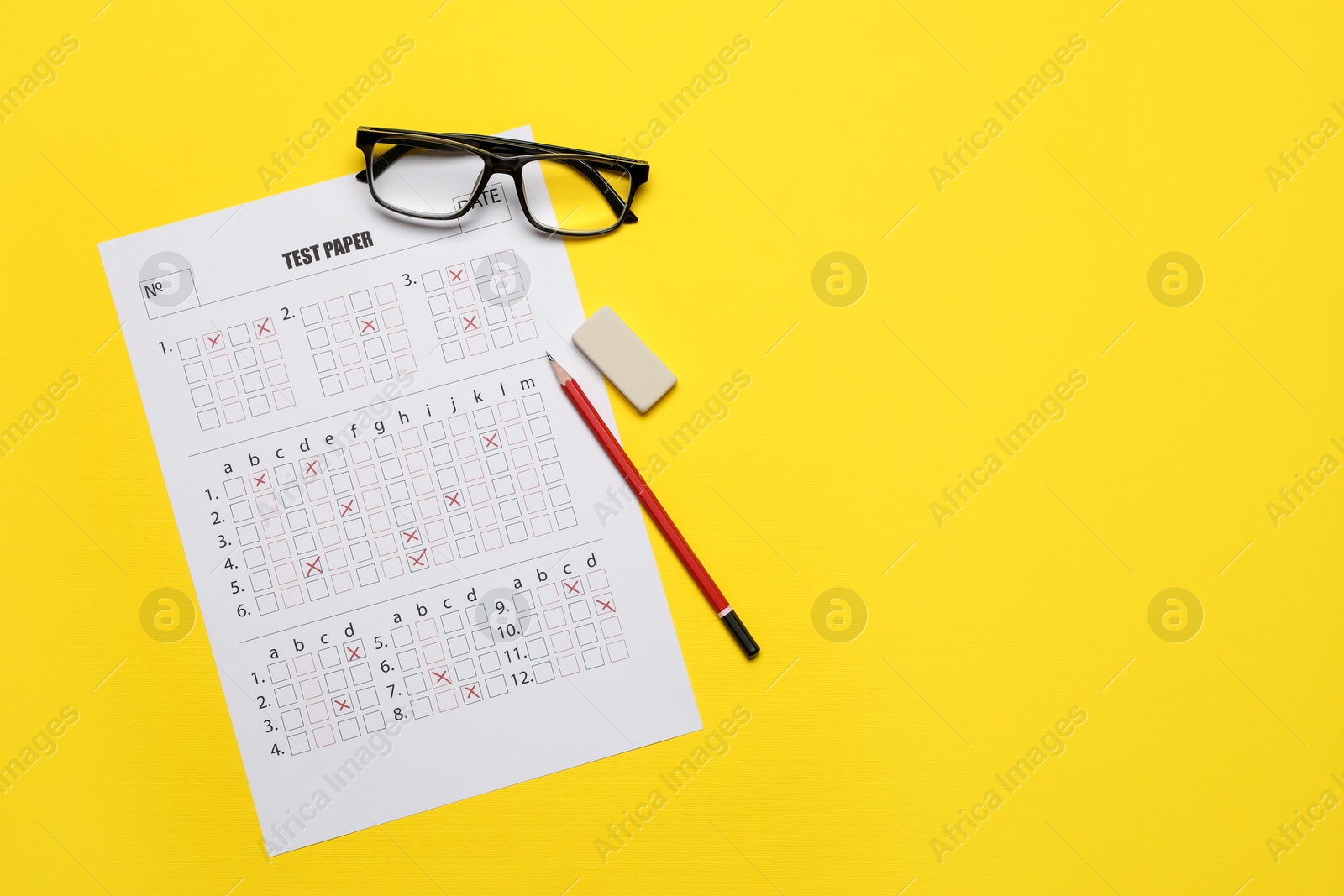 Student passing exam. Answer sheet, glasses, pencil and eraser on yellow background, flat lay. Space for text Photo of Student passing exam. Answer sheet, glasses, pencil and eraser on yellow background, flat lay. Space for text
