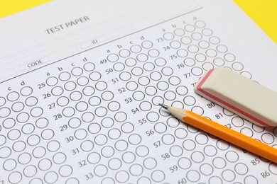 Photo of Answer sheet, pencil and eraser on table, closeup. Student passing exam