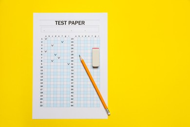 Photo of Student passing exam. Answer sheet, pencil and eraser on yellow background, flat lay. Space for text