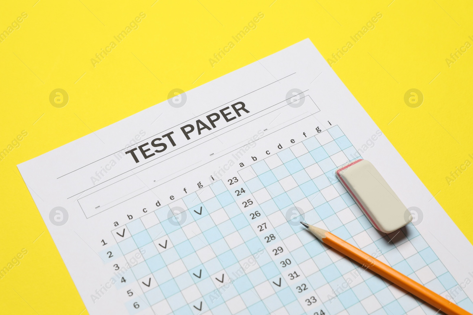 Photo of Answer sheet, pencil and eraser on yellow background, closeup. Student passing exam