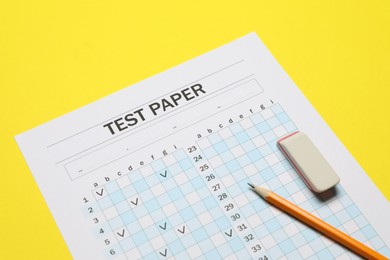 Photo of Answer sheet, pencil and eraser on yellow background, closeup. Student passing exam