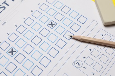 Photo of Answer sheet, pencil and eraser, closeup. Student passing exam