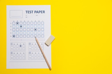 Photo of Student passing exam. Answer sheet, pencil and eraser on yellow background, flat lay. Space for text