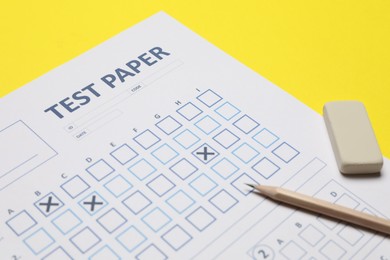 Photo of Answer sheet, pencil and eraser on yellow background, closeup. Student passing exam
