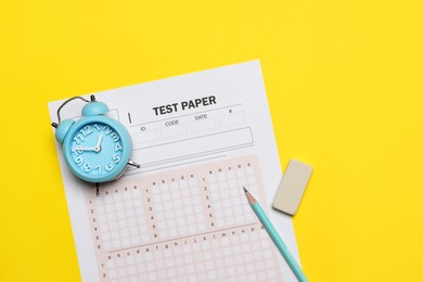 Photo of Answer sheet, alarm clock, pencil and eraser on yellow background, flat lay. Student passing exam