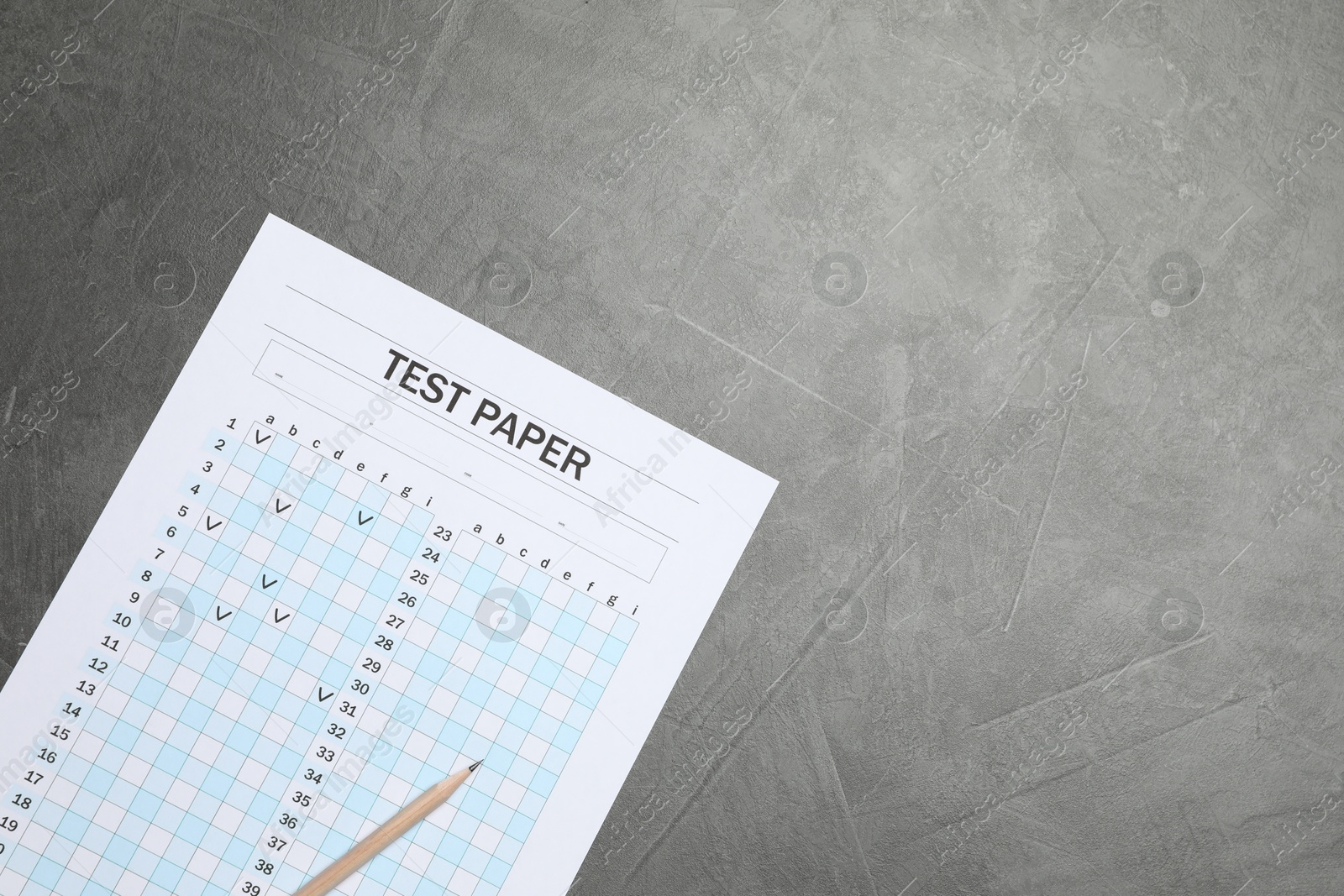 Photo of Student passing exam. Answer sheet and pencil on gray textured table, flat lay. Space for text