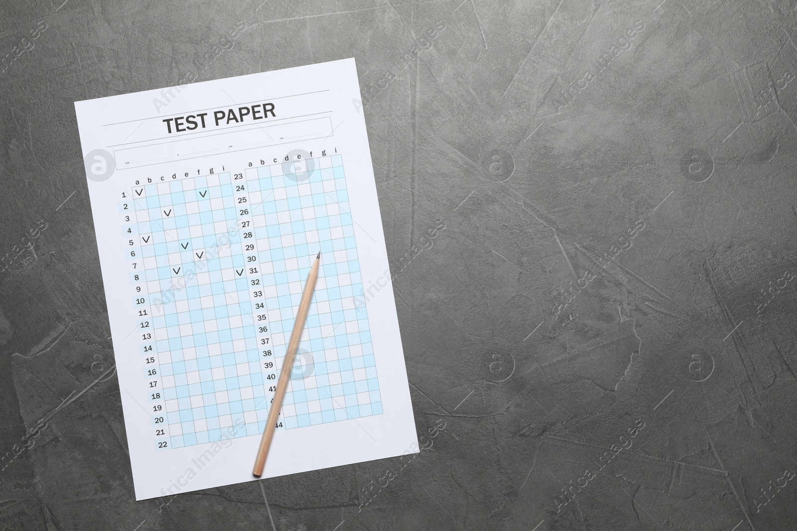 Photo of Student passing exam. Answer sheet and pencil on gray textured table, flat lay. Space for text