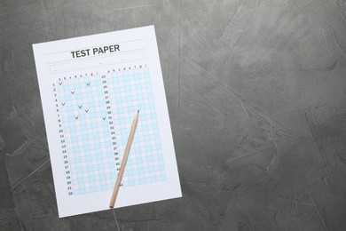 Photo of Student passing exam. Answer sheet and pencil on gray textured table, flat lay. Space for text