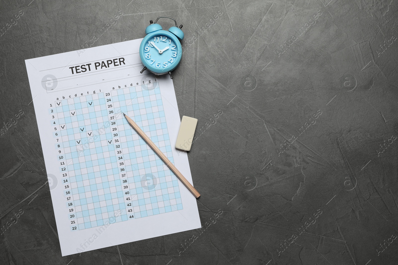 Photo of Student passing exam. Answer sheet, alarm clock, pencil and eraser on gray textured table, flat lay. Space for text
