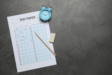 Photo of Student passing exam. Answer sheet, alarm clock, pencil and eraser on gray textured table, flat lay. Space for text