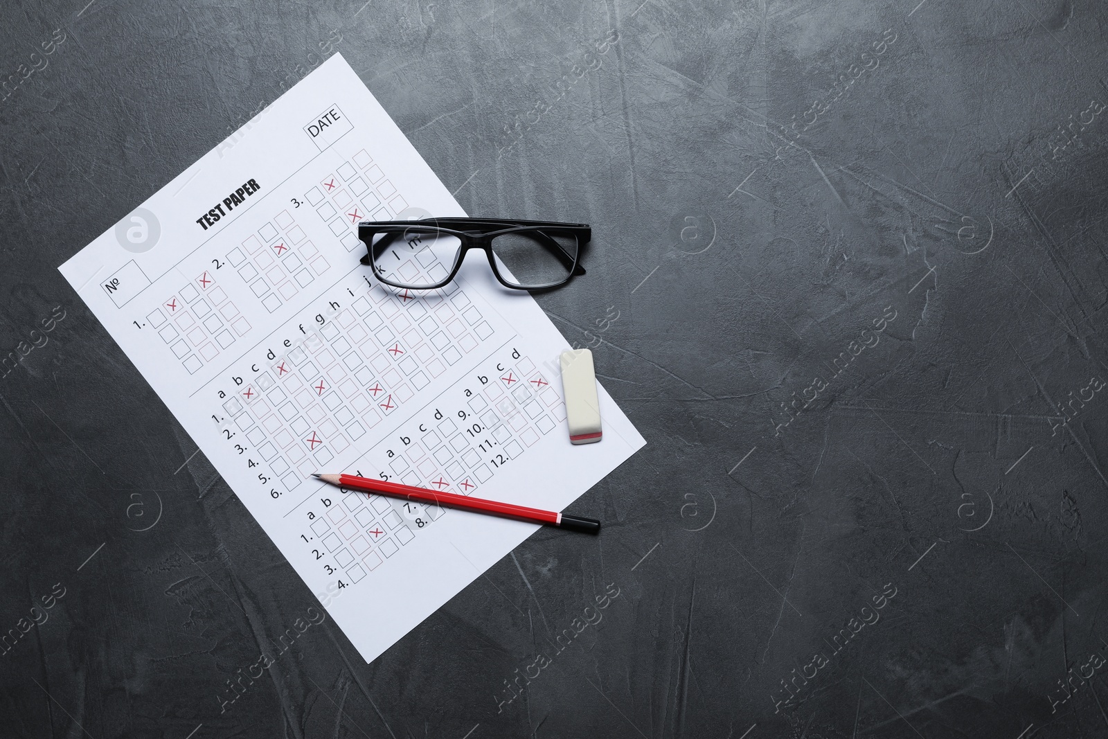 Photo of Student passing exam. Answer sheet, glasses, pencil and eraser on gray textured table, flat lay. Space for text